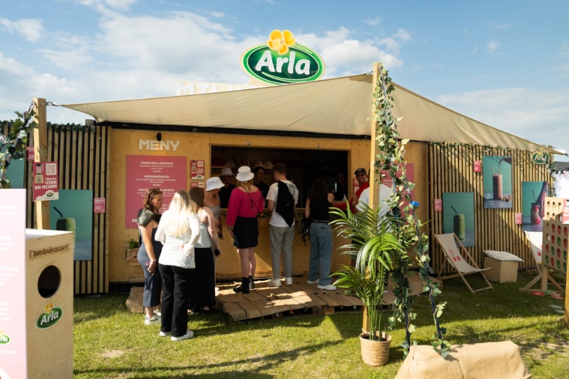The Arla stand at Summer On, a wooden pavilion with plants and visitors