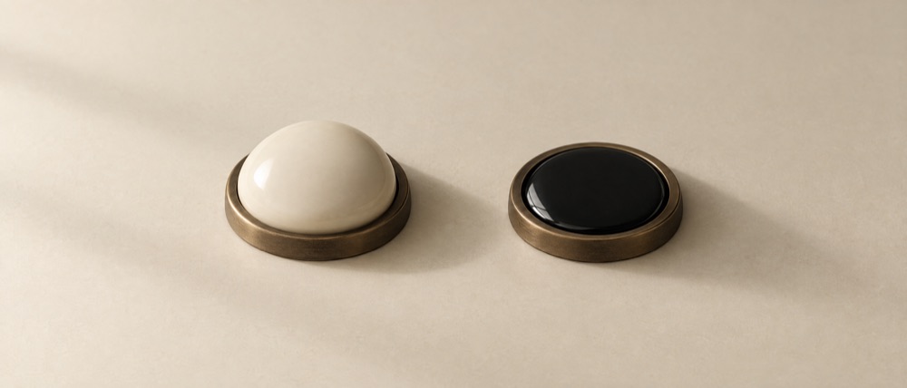 Photograph: two domed press-buttons side by side, the pale one untouched, the black one pressed flat into its base